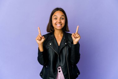 Genç melez kadın iki elini de havaya kaldırarak boş bir alan gösteriyor..