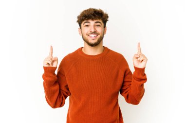 Beyaz arka plandaki genç Arap, iki ön parmağı da boş bir alan gösterirken....