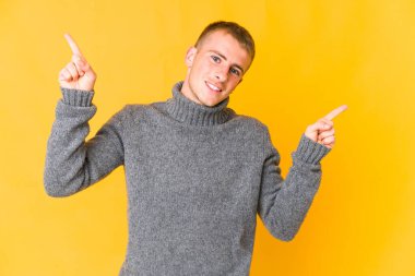 Kafkasyalı yakışıklı adam farklı kopyaları gösteriyor, birini seçiyor, parmaklarıyla gösteriyor..