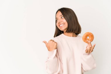 Genç İspanyol bir kadın başparmağıyla çörek yiyor, gülüyor ve kaygısız..