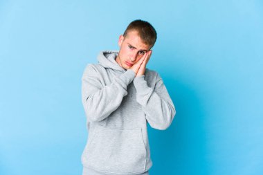 Beyaz tenli yakışıklı adam esniyor. Ağzı eliyle kapatan yorgun bir jest yapıyor..