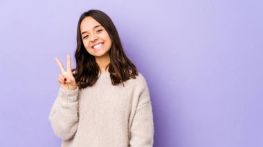 Genç, melez, Latin bir kadın iki numarayı parmaklarıyla gösteriyor..