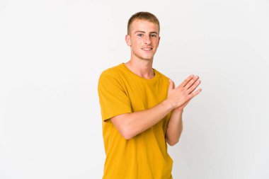 Genç beyaz yakışıklı adam enerjik ve rahat hissediyor, ellerini ovuşturuyor kendinden emin..
