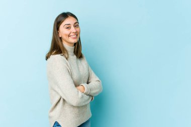 Kendine güveni tam genç bir beyaz kadın, kararlılıkla kollarını kavuşturuyor..