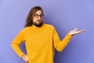 Uzun saçlı genç adam şüpheli görünüyor ve sorgulama sırasında omuzlarını silkiyor..