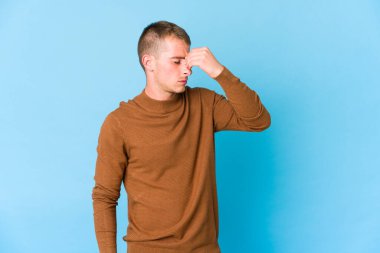 Kafkasyalı yakışıklı genç adamın başı ağrıyor, yüzüne dokunuyor..