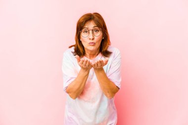 Üst düzey beyaz kadın, dudaklarını katlayıp, avuç içleriyle hava öpücüğü yolluyor..