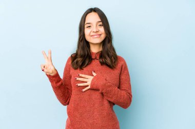 Genç, melez, Latin bir kadın tek başına yemin ediyor, elini göğsüne koyuyor..