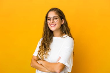 Kendine güveni tam genç bir beyaz kadın, kararlılıkla kollarını kavuşturuyor..