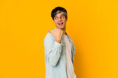 Genç, sıska, ispanyol parmakla işaret ediyor, gülüyor ve kaygısız..