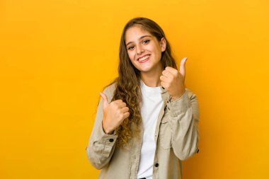 Kafkasyalı genç bir kadın iki parmağını da kaldırıyor, gülümsüyor ve kendinden emin..