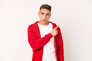 Genç, beyaz, yakışıklı bir adam tek başına, yan tarafı işaret ediyor.