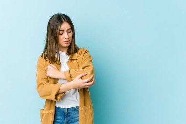 Genç beyaz kadın dirsek masajı yapıyor, kötü bir hareketin ardından acı çekiyor..