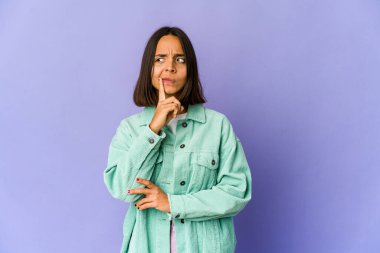 Genç melez kadın şüpheli ve şüpheci bir ifadeyle yan bakıyor..