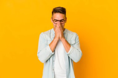 Genç, yakışıklı, beyaz tenli, izole edilmiş, el ele dua eden, kendine güvenen bir adam..