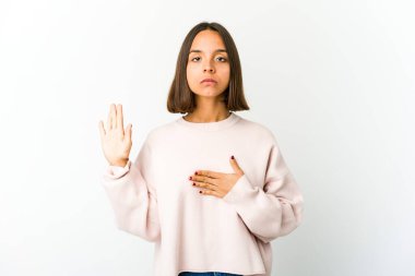 Genç melez kadın yemin ediyor, elini göğsüne koyuyor..