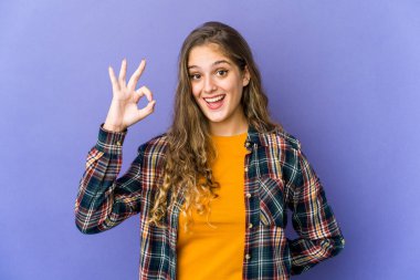 Genç, beyaz, tatlı bir kadın göz kırpıyor ve elleriyle iyi bir jest yapıyor..