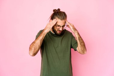 Uzun saçlı genç adam tapınaklara dokunuyor ve baş ağrısı çekiyor..