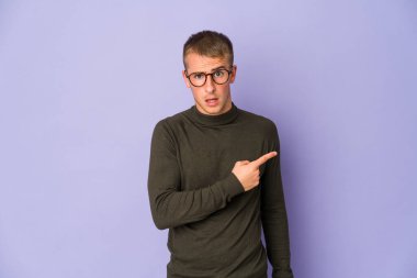 Kafkasyalı yakışıklı genç adam yan tarafı işaret ediyor.