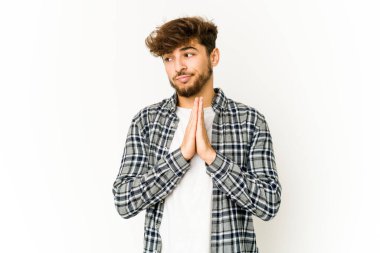 Beyaz arka planda dua eden, kendini adamış dindar, ilahi ilhamı arayan genç bir Arap..