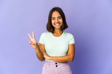 Genç melez kadın iki numarayı parmaklarıyla gösteriyor..