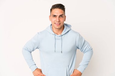 Beyaz tenli yakışıklı, izole edilmiş, kendine güveni olan ellerini kalçasında tutan bir adam..