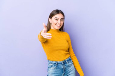 Beyaz bir kadın kameraya elini uzatıp selam veriyor..