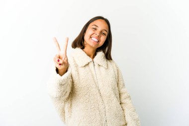 Genç melez kadın neşeli ve kaygısız parmaklarıyla barış sembolü gösteriyor..