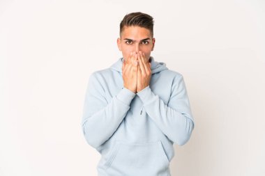 Beyaz tenli yakışıklı adam şok olmuş, ağzı ellerle kaplanmış, yeni bir şey keşfetmek için sabırsızlanıyor..