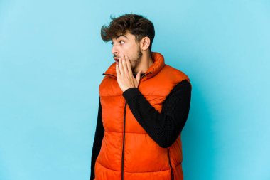 Mavi arka plandaki genç Arap adam gördüğü bir şey yüzünden şoka uğruyor..