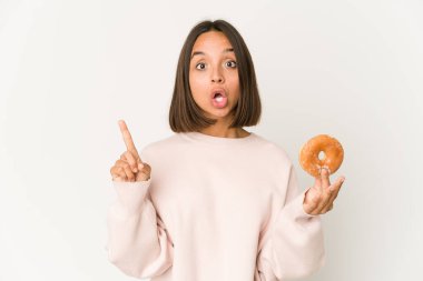 Genç İspanyol kadın çörek yiyor. Harika bir fikri var. Yaratıcılık kavramı..