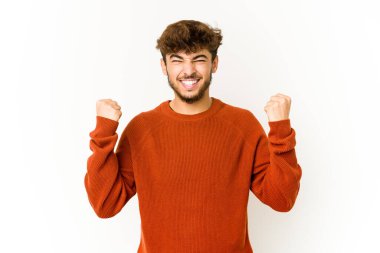 Beyaz arka planda genç bir Arap tasasız ve heyecanlı tezahüratlar yapıyor. Zafer konsepti.