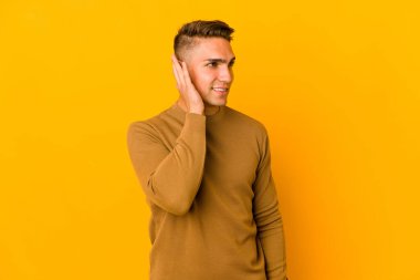 Genç, yakışıklı, beyaz bir adam bir dedikoduyu dinlemeye çalışıyor..