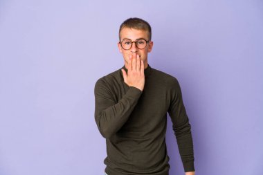 Genç, beyaz, yakışıklı adam şok olmuş, ağzı ellerle kaplanmış, yeni bir şey keşfetmek için sabırsızlanıyor..