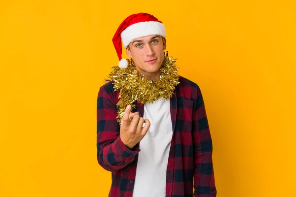 크리스마스 모자를 배경에 선물을 코카서스 남자가 당신을 초대하는 것처럼 손가락으로 — 스톡 사진