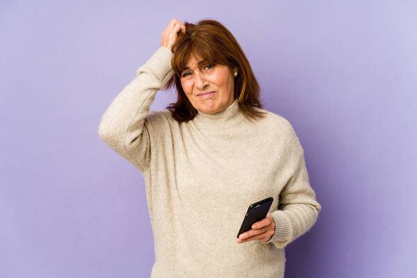 Кавказская женщина средних лет, держащая телефон в шоке, она вспомнила важную встречу.