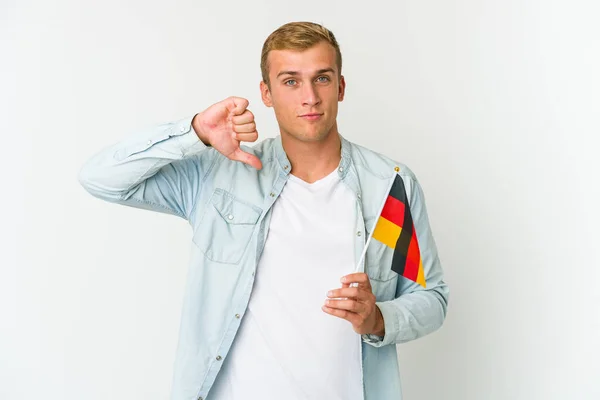 白人の背景にドイツ国旗を掲げた若い白人男性は 嫌なジェスチャー 親指を下に示しています 意見の相違 — ストック写真
