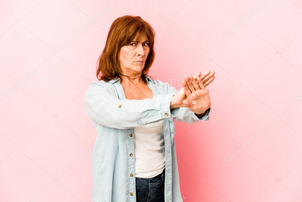 Senior caucasian woman isolated standing with outstretched hand showing stop sign, preventing you.