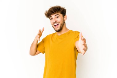 Beyaz arka plandaki genç Arap, kameraya sarıldığı için kendinden emin..