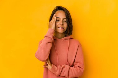 Sarıda izole edilmiş genç İspanyol kadın bir şeyi unutuyor. Alnına avuç içi ile vuruyor ve gözlerini kapıyor..