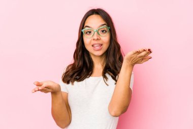 Genç, melez İspanyol bir kadın soyutlanmış, kollarıyla ölçek yapıyor, mutlu ve kendinden emin hissediyor..