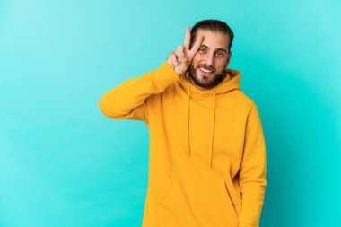 Uzun saçlı genç adam iki numarayı parmaklarıyla gösteriyor..