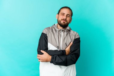 Uzun saçlı genç adam kendine güvenen, kararlılıkla kollarını kavuşturan..