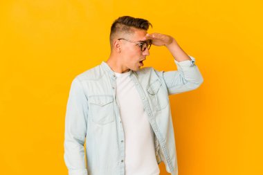 Genç, yakışıklı, beyaz tenli, soyutlanmış, uzaklara bakan, elini alnında tutan bir adam..