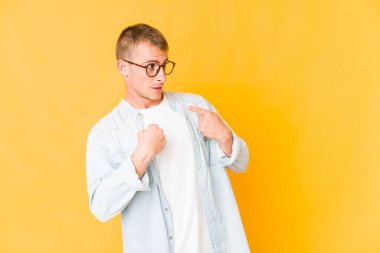 Genç, beyaz, yakışıklı bir adam parmağını gösterip, gülümseyerek şaşırdı..