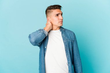 Beyaz tenli yakışıklı bir adam stres yüzünden boynu ağrıyor. Masaj yapıyor ve eliyle dokunuyor..