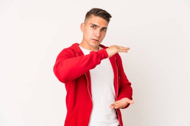 Beyaz tenli yakışıklı bir adam iki eliyle bir şey tutuyor, ürün sunumu..