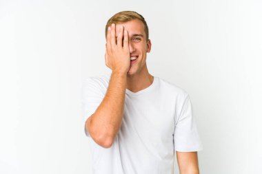 Beyaz tenli yakışıklı adam yüzünün yarısını palmiyeyle örterek eğleniyor..