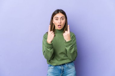 Kafkasyalı genç bir kadın ağzı açık bir şekilde üst tarafı işaret ediyor..