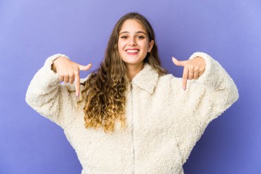 Beyaz tenli hoş bir kadın parmaklarıyla aşağı işaret ediyor, olumlu bir his..